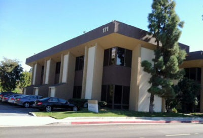 A building with cars parked on the side of it.