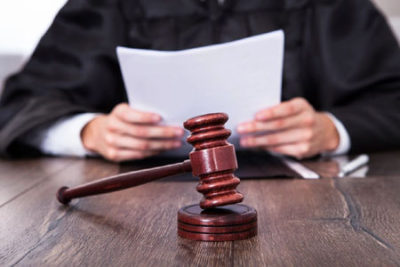 A judge sitting at his desk with papers and gavel.