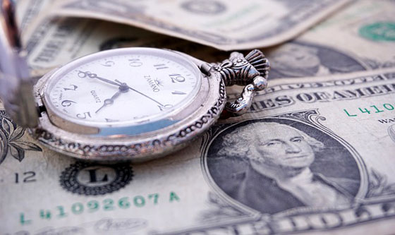 A close up of a pocket watch on top of money