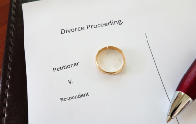 A wedding ring sitting on top of papers.